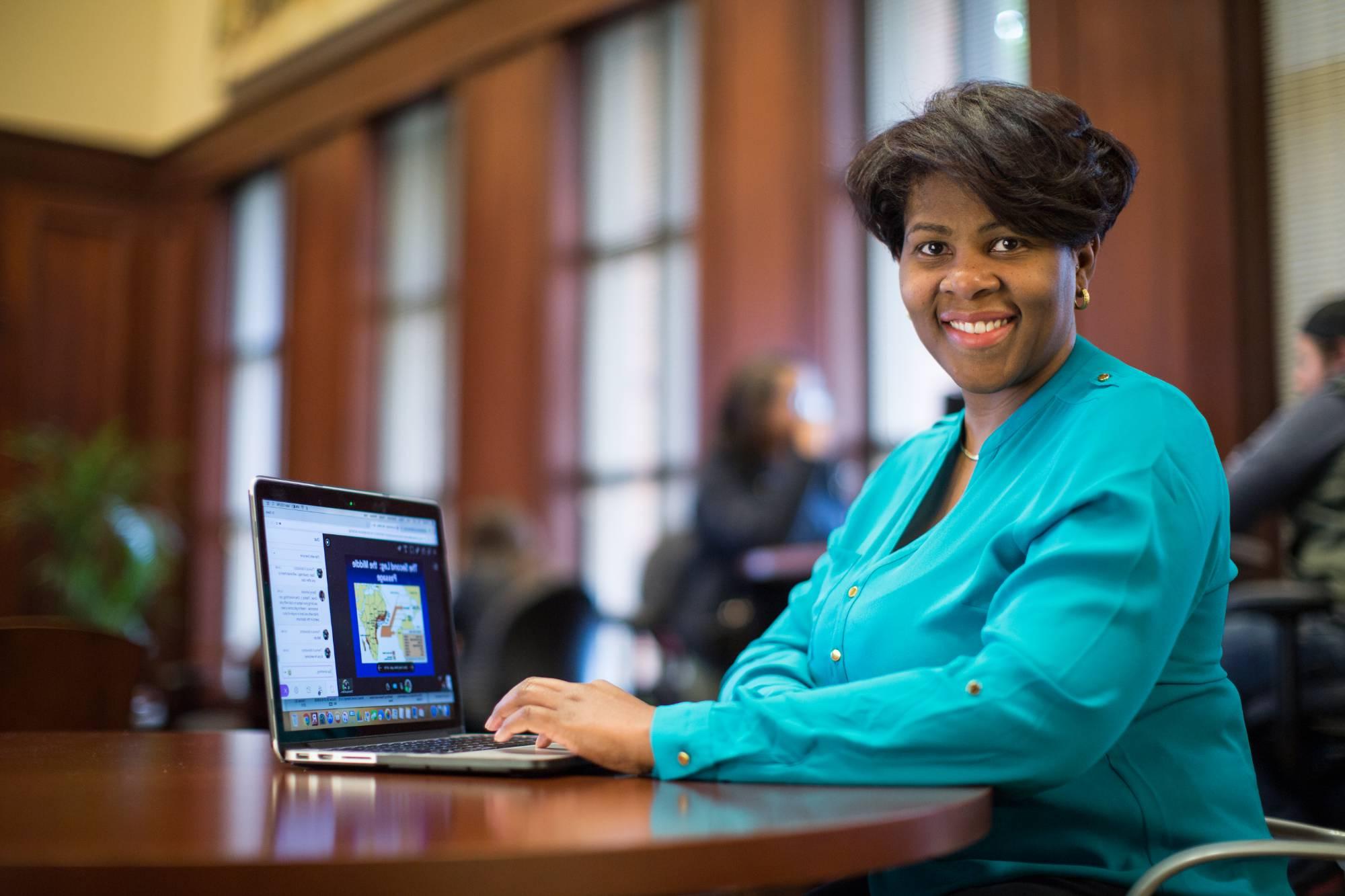 Faculty member with a laptop utilizing online orientation modules